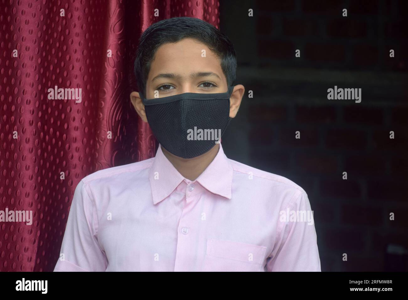 teen student boy wearing school uniform and face mask going to school in corona virus pandemic. Stock Photo