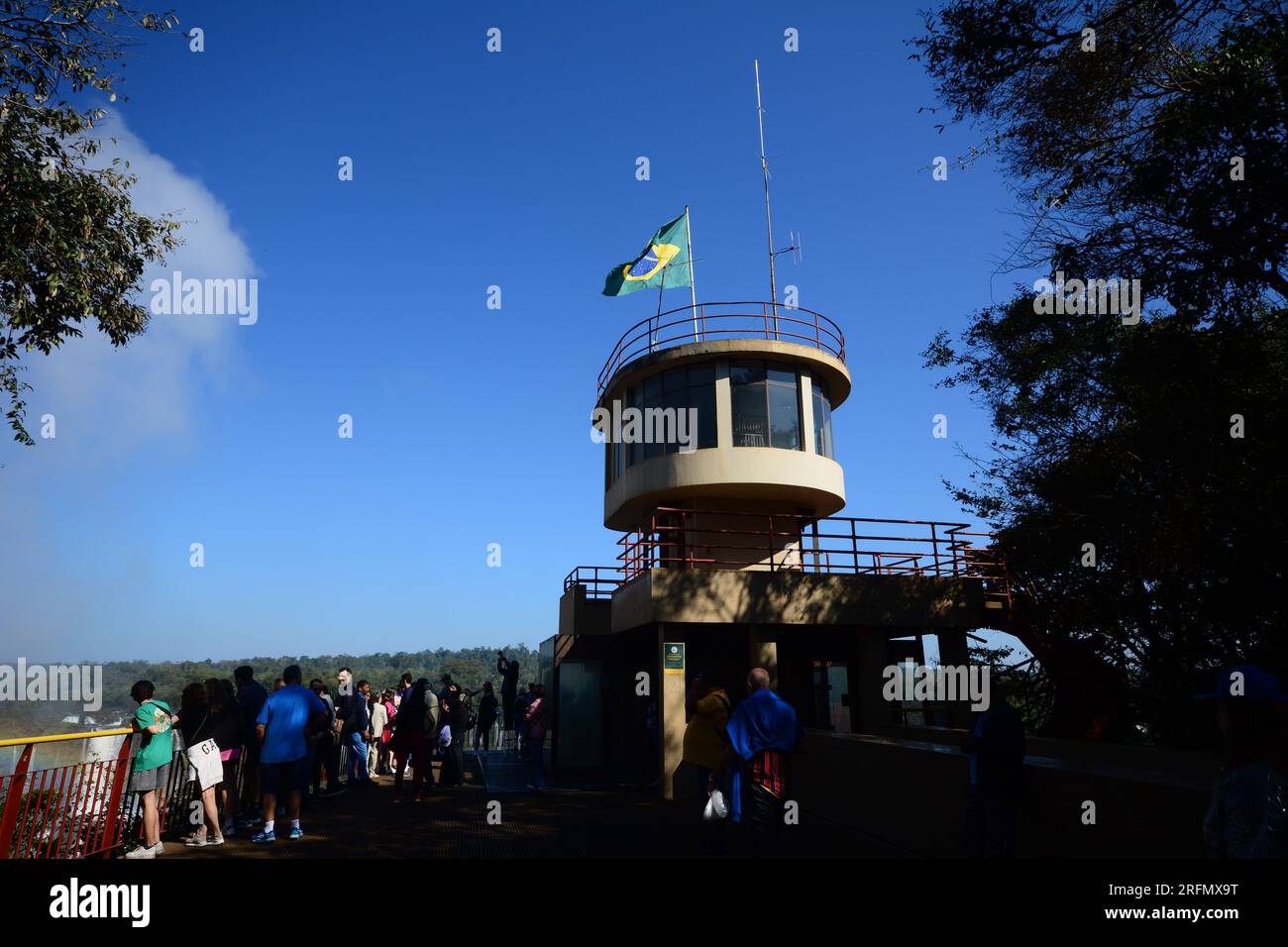 Facade of the panoramic elevator at the Iguazu Falls with the Brazilian flag on top and tourists enjoying the view Stock Photo