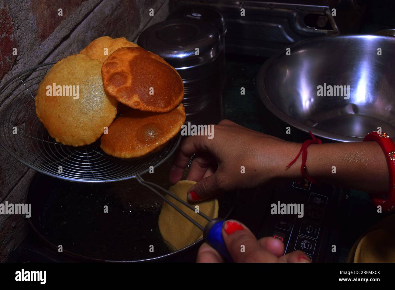 modern black induction stove, Woman standing in kitchen cooking food