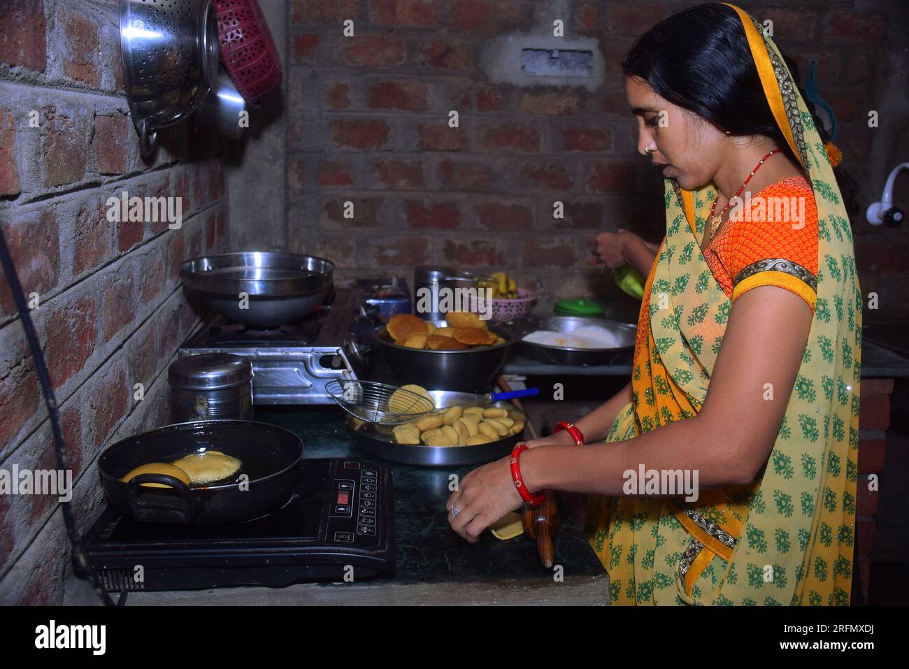 modern black induction stove, Woman standing in kitchen cooking food
