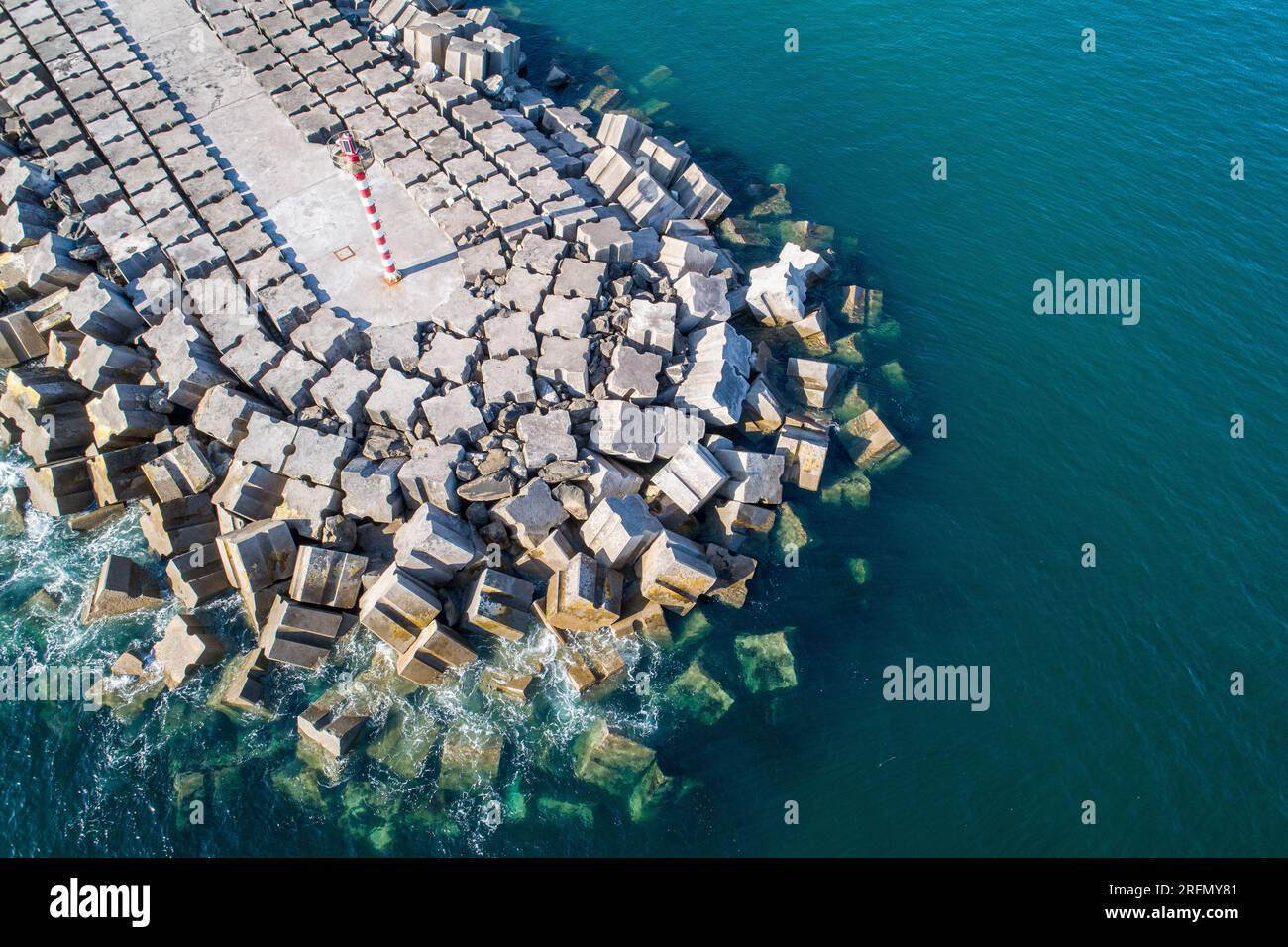 Stone breakwater with a lighthouse aerial drone view Stock Photo
