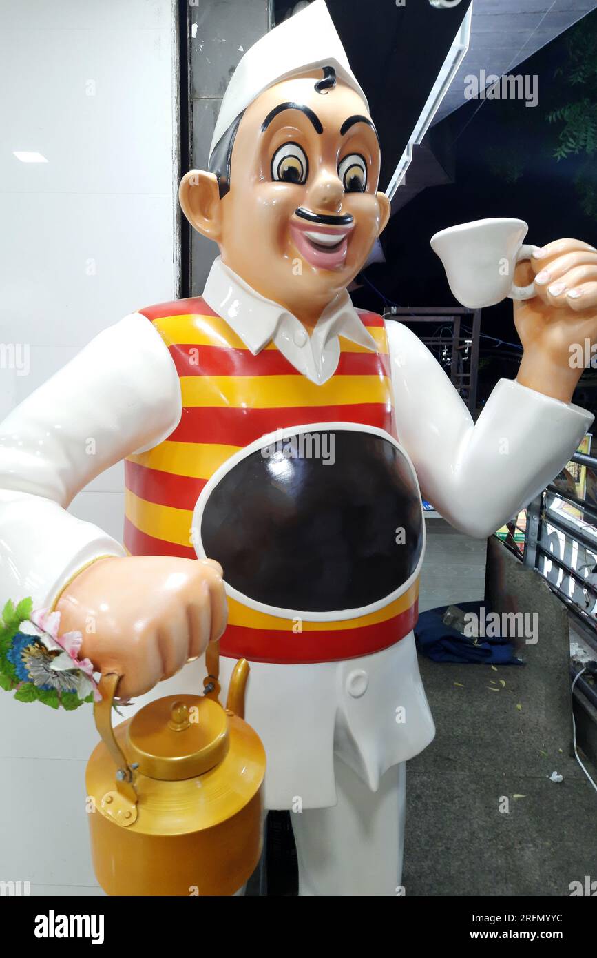 Traditionally dressed mannequin with tea and kettle in front of Indian