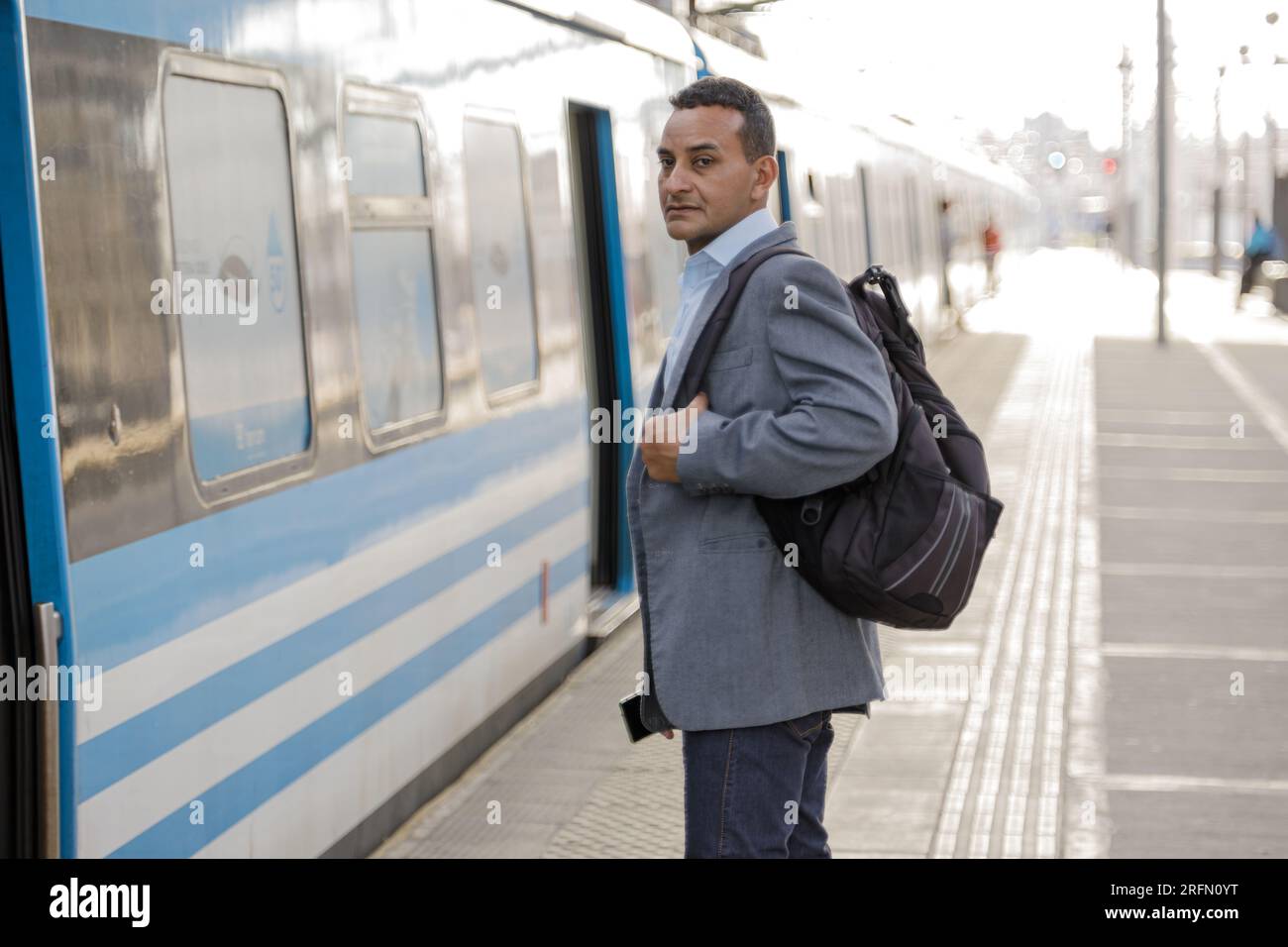 Latin man in a suit waiting at train station. Stock Photo