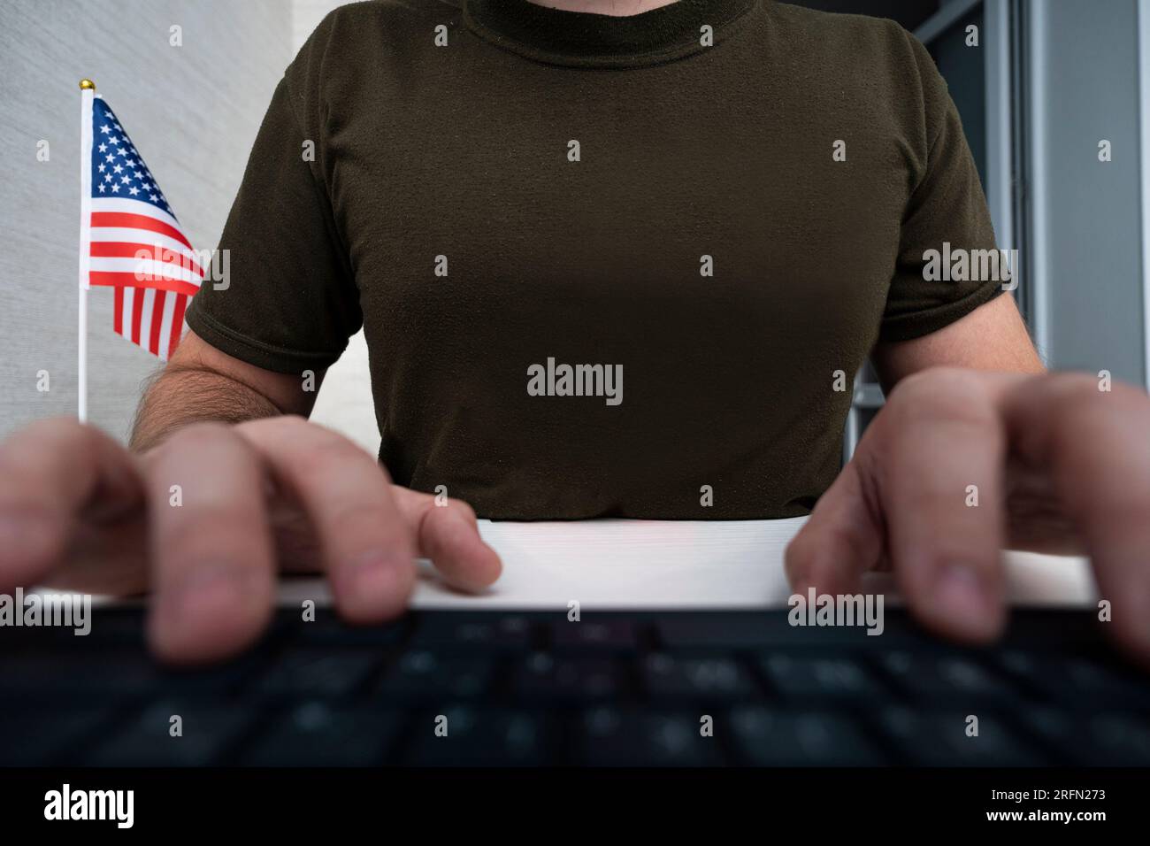 a male soldier in a military uniform is sitting at a computer. center for special military psychological operations Of usa. The concept of information Stock Photo