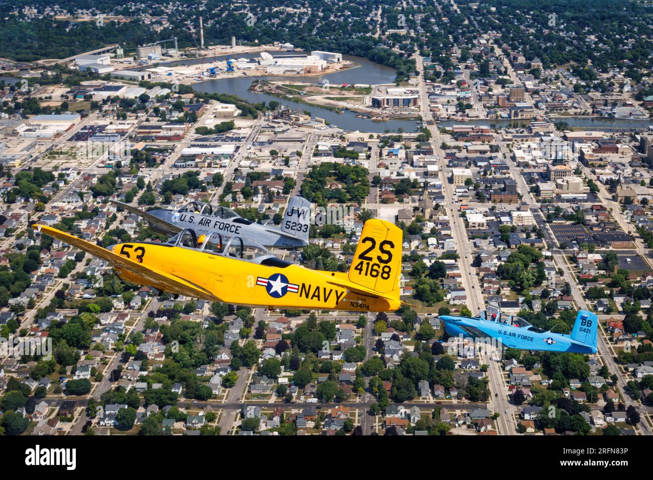 Three Beechcraft T-34 Mentors in formation over Manitowoc, Wisconsin approaching Lake Michigan. Stock Photo