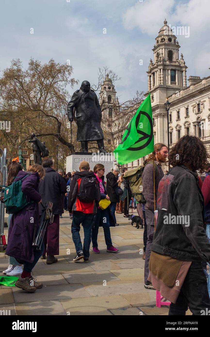 London, UK, 2023. Extinction Rebellion activists mark Earth Day at climate protest in Parliament Square with the statue of Churchill in the background Stock Photo