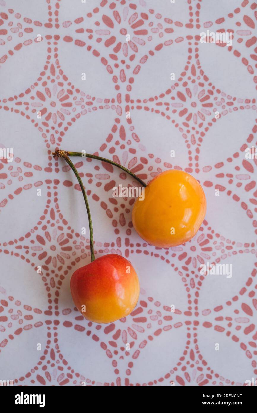 two attached Rainier cherries on moroccan pink and white patterned platter Stock Photo