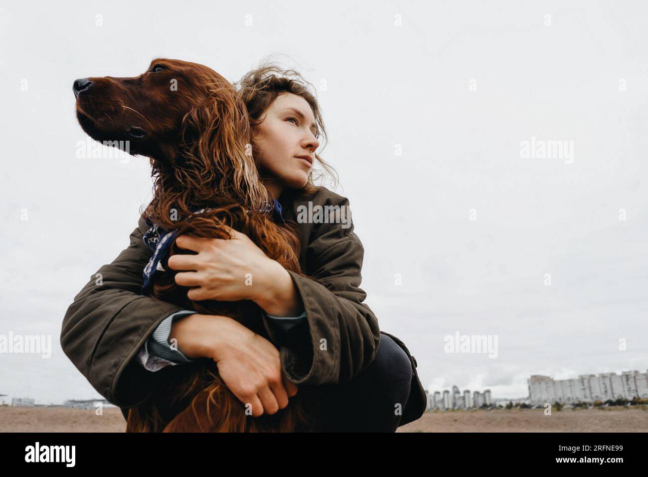 Portrait of a young woman with her dog. Irish setter dog in the arms of the loving mistress. Stock Photo