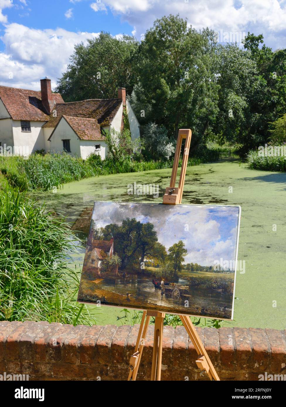Photograph of John Constable's the Hay Wain on easel taken in the same spot the picture was painted - Flatford, Suffolk, England Stock Photo