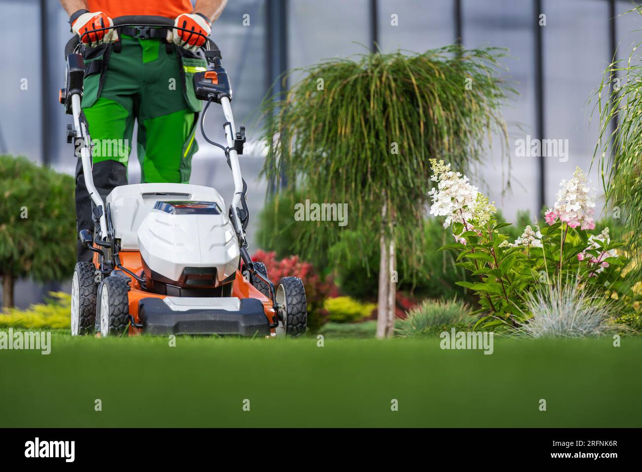 Landscaping Garden Keeping Worker Mowing Back Yard Lawn Using Electric