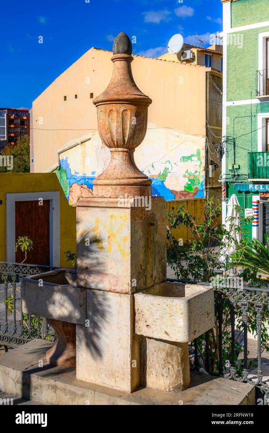 Villajoyosa, Spain, Drinking water fountain with a stone capital structure. It is located in a small park or parkette. Stock Photo