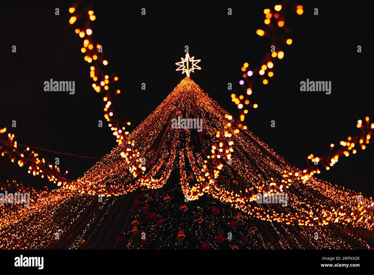 Golden magic twinkling bokeh lights of festive Christmas tree. New Year gold background Stock Photo