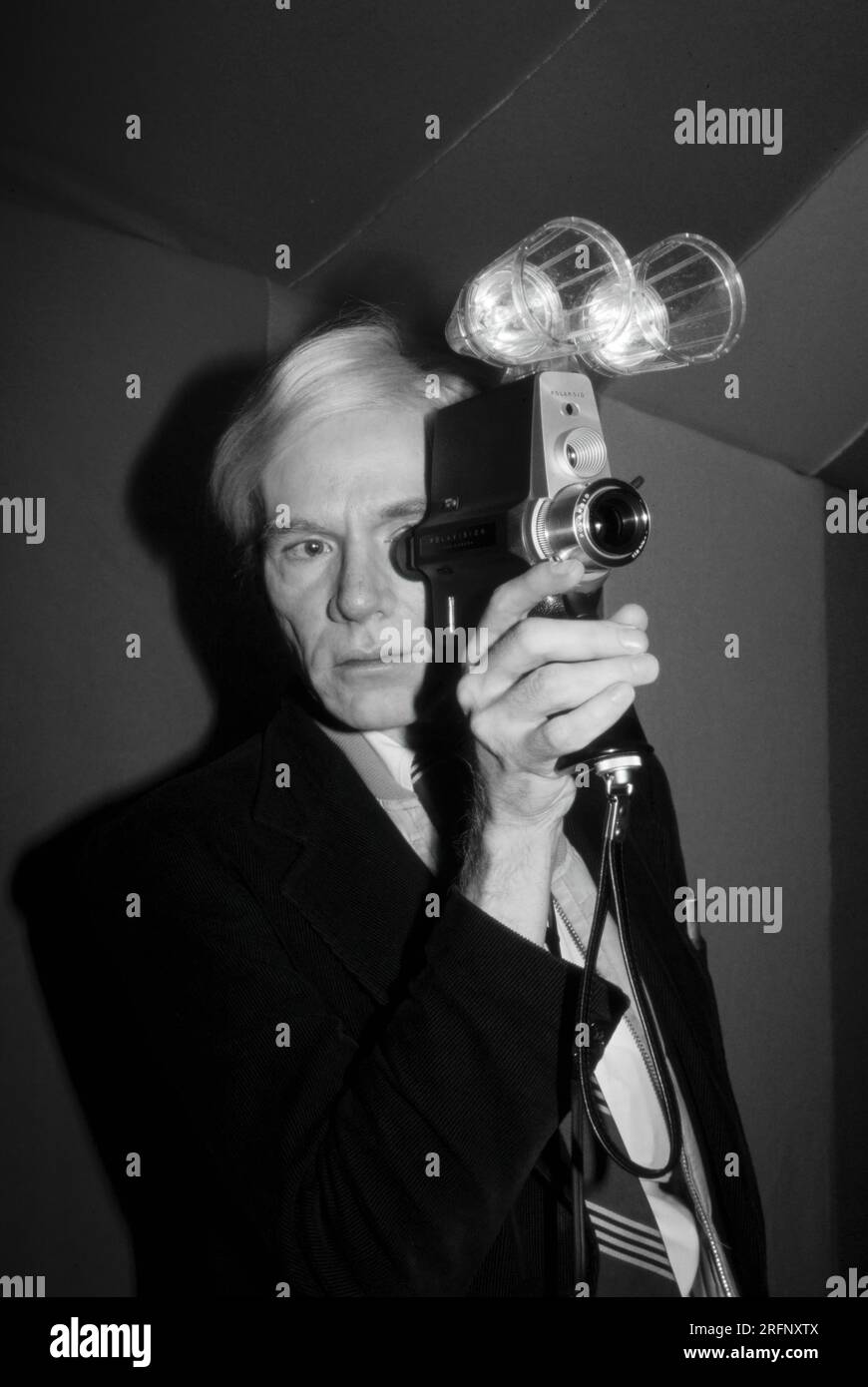 Andy Warhol with new Polaroid Polavision movie camera at an art opening