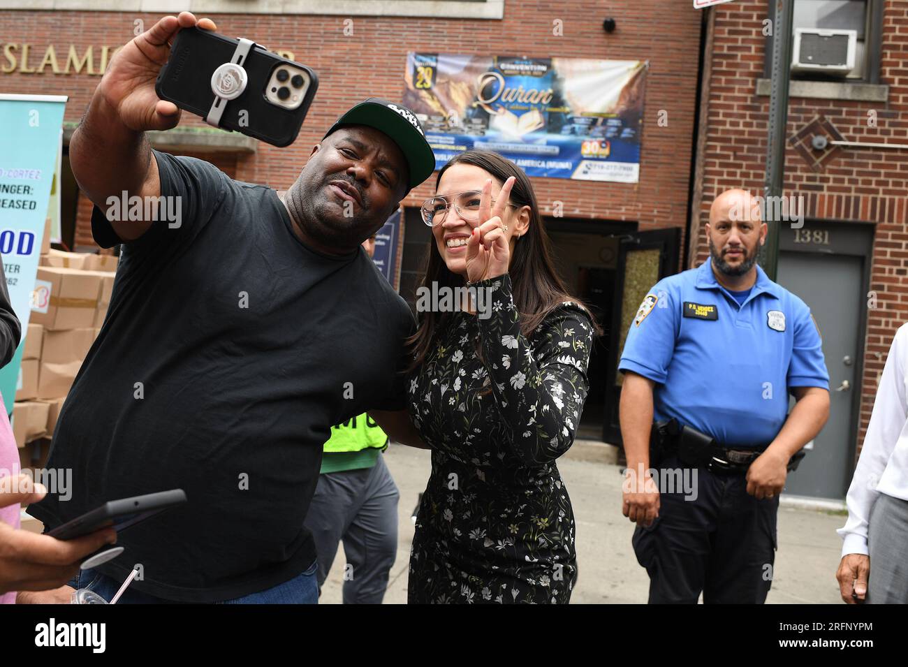 New York, USA. 04th Aug, 2023. Rep. Alexandria Ocasio-Cortez (l) poses for a pictures after a press conference and participating in ‘halal' food distribution outside the Parkchester Islamic Center in the New York City borough of the Bronx, NY, August 4, 2023. Rep. Ocasio-Cortez outlined her efforts to increase access to halal and kosher food in the 2023 federal ‘Farm bill', as Muslim and Jewish families struggle to afford food that meets their faith's dietary guidelines. (Photo by Anthony Behar/Sipa USA) Credit: Sipa USA/Alamy Live News Stock Photo