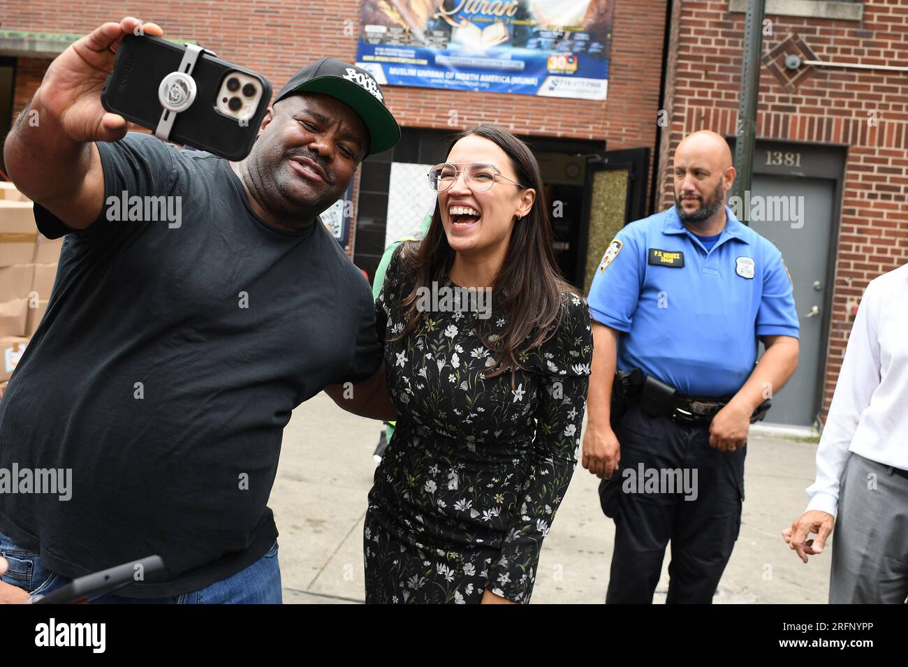 New York, USA. 04th Aug, 2023. Rep. Alexandria Ocasio-Cortez (l) reacts while posing for a pictures after a press conference and participating in ‘halal' food distribution outside the Parkchester Islamic Center in the New York City borough of the Bronx, NY, August 4, 2023. Rep. Ocasio-Cortez outlined her efforts to increase access to halal and kosher food in the 2023 federal ‘Farm bill', as Muslim and Jewish families struggle to afford food that meets their faith's dietary guidelines. (Photo by Anthony Behar/Sipa USA) Credit: Sipa USA/Alamy Live News Stock Photo
