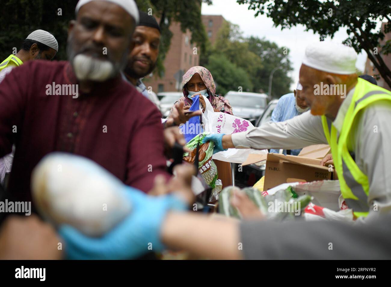 New York, USA. 04th Aug, 2023. People receive donated ‘halal' food outside the Parkchester