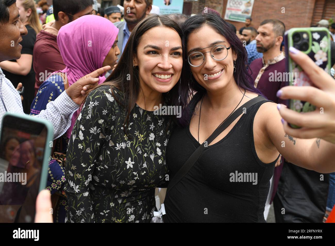 New York, USA. 04th Aug, 2023. Rep. Alexandria Ocasio-Cortez (l) poses for a pictures with Raven Gomez after a press conference and participating in ‘halal' food distribution outside the Parkchester Islamic Center in the New York City borough of the Bronx, NY, August 4, 2023. Rep. Ocasio-Cortez outlined her efforts to increase access to halal and kosher food in the 2023 federal ‘Farm bill', as Muslim and Jewish families struggle to afford food that meets their faith's dietary guidelines. (Photo by Anthony Behar/Sipa USA) Credit: Sipa USA/Alamy Live News Stock Photo