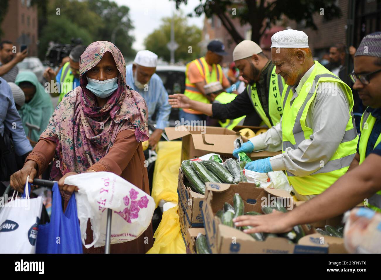 New York, USA. 04th Aug, 2023. People receive donated ‘halal' food outside the Parkchester