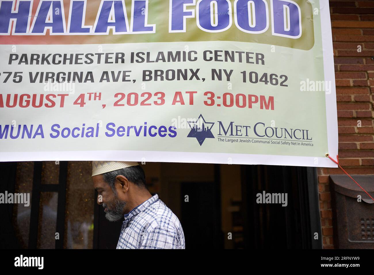 New York, USA. 04th Aug, 2023. A man stands under a banner announcing ‘halal' food distribution organized by Rep. Alexandria Ocasio-Cortez who attended the event at the Parkchester Islamic Center in the New York City borough of the Bronx, NY, August 4, 2023. Rep. Ocasio-Cortez outlined her efforts to increase access to halal and kosher food in the 2023 federal ‘Farm bill', as Muslim and Jewish families struggle to afford food that meets their faith's dietary guidelines. (Photo by Anthony Behar/Sipa USA) Credit: Sipa USA/Alamy Live News Stock Photo