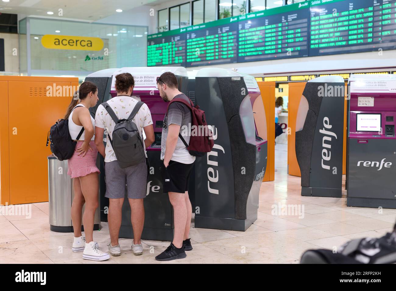 04.08.2023. Barcelona, Spain, young people getting media distance tickets inside the Barcelona Sants train station Stock Photo