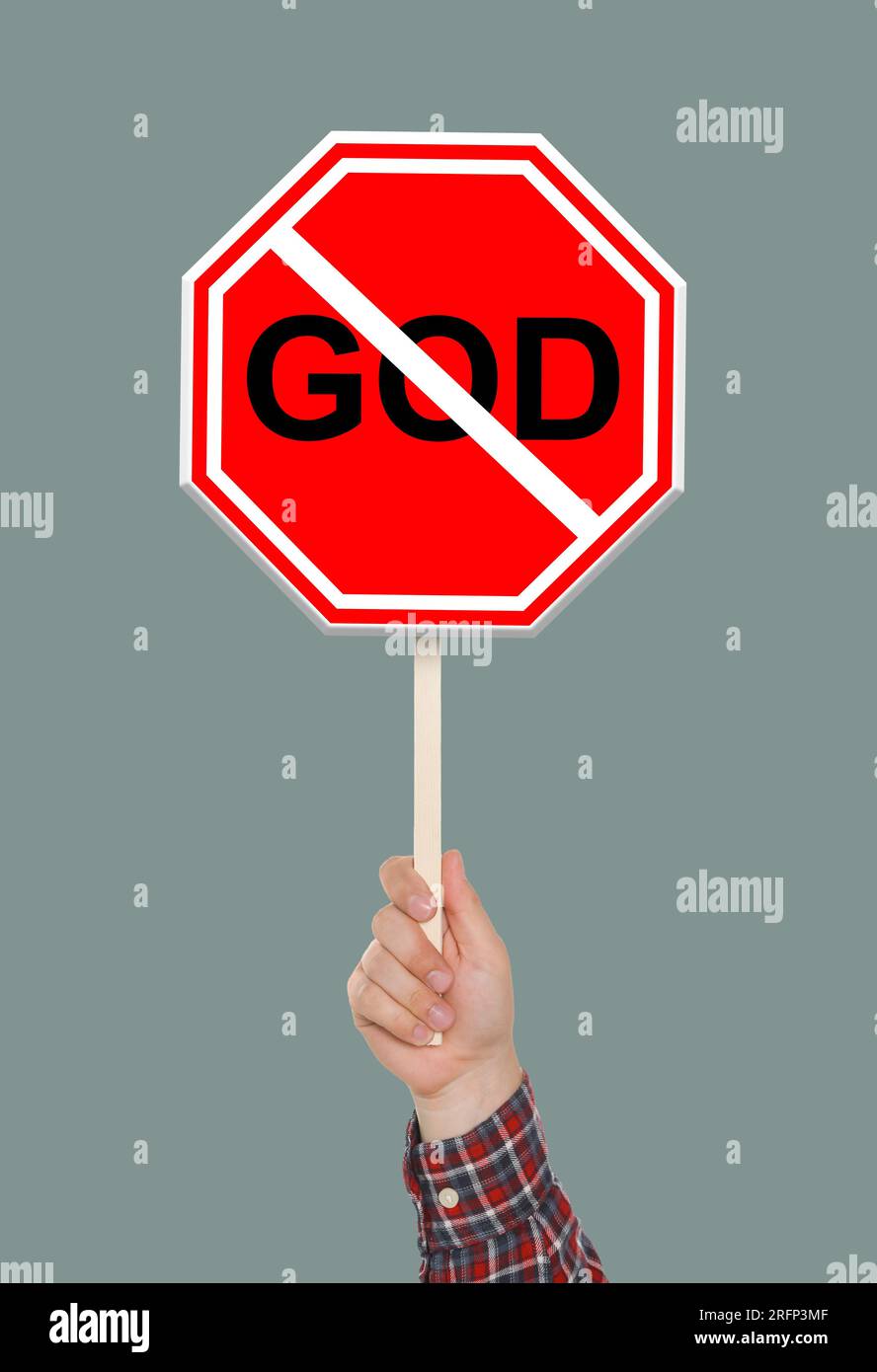 Atheism concept. Man holding prohibition sign with crossed out word God on grey background Stock Photo