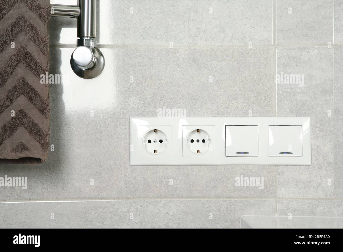 Light switches and power sockets on light grey wall in bathroom Stock Photo - Alamy