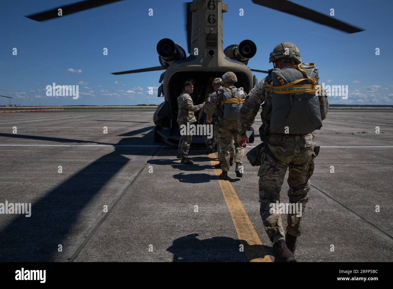 A group of International Paratroopers load a Ch-47 Chinook Helicopter during Leapfest at the Quonset Army Aviation Support Facility in Washington County, Rhode Island, August 2, 2023. Leapfest is the largest, longest standing, international static line parachute training event and competition hosted by the 56th Troop Command, Rhode Island Army National Guard to promote high level technical training and esprit de corps within the International Airborne community. (U.S. Army Reserve photo by Sgt. Eric Kestner) Stock Photo