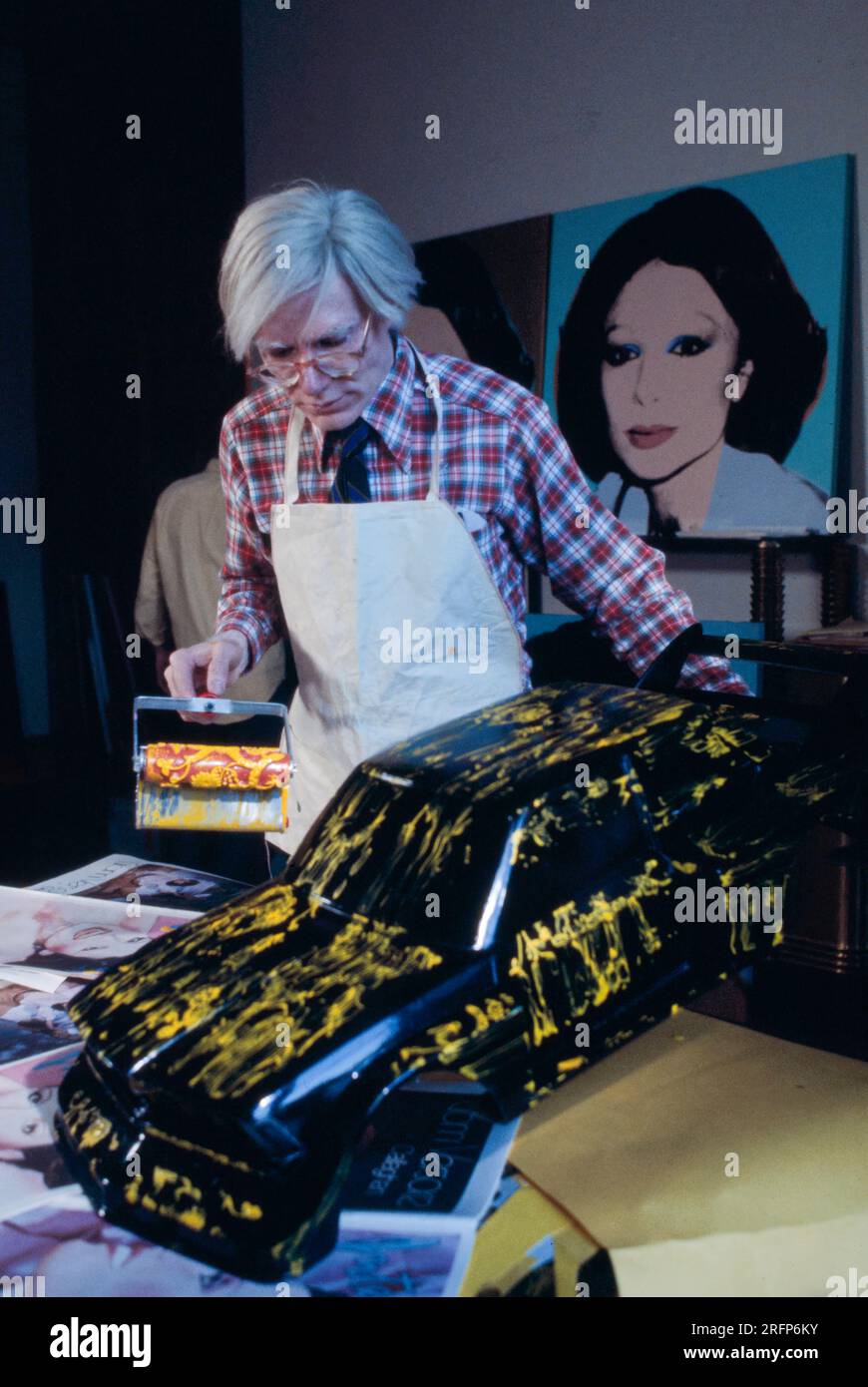 Andy Warhol paints a model car in a performance in New York in 1978