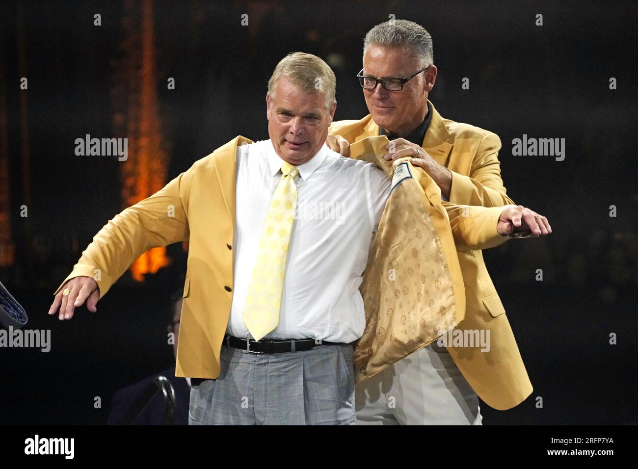 Joe Klecko, left, a member of the Pro Football Hall of Fame Class of 2023,  receives his gold jacket from Howie Long during the gold jacket dinner in  Canton, Ohio, Friday, Aug.