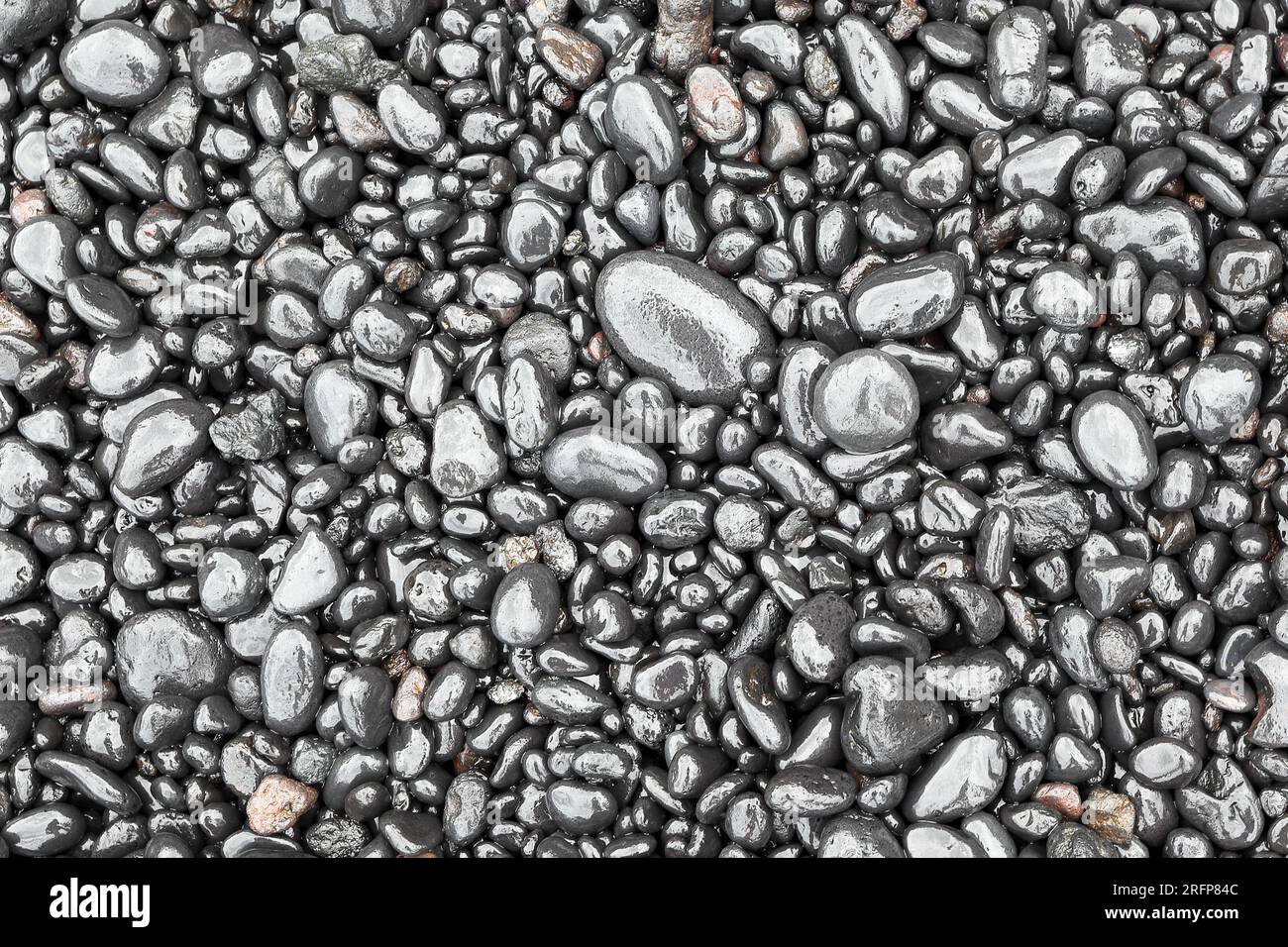 Wet black beach pebbles full frame background Stock Photo - Alamy
