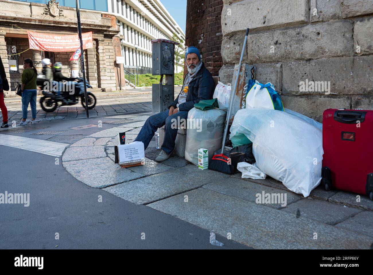 Homeless man on the sidewalk in Milan, Italy Stock Photo