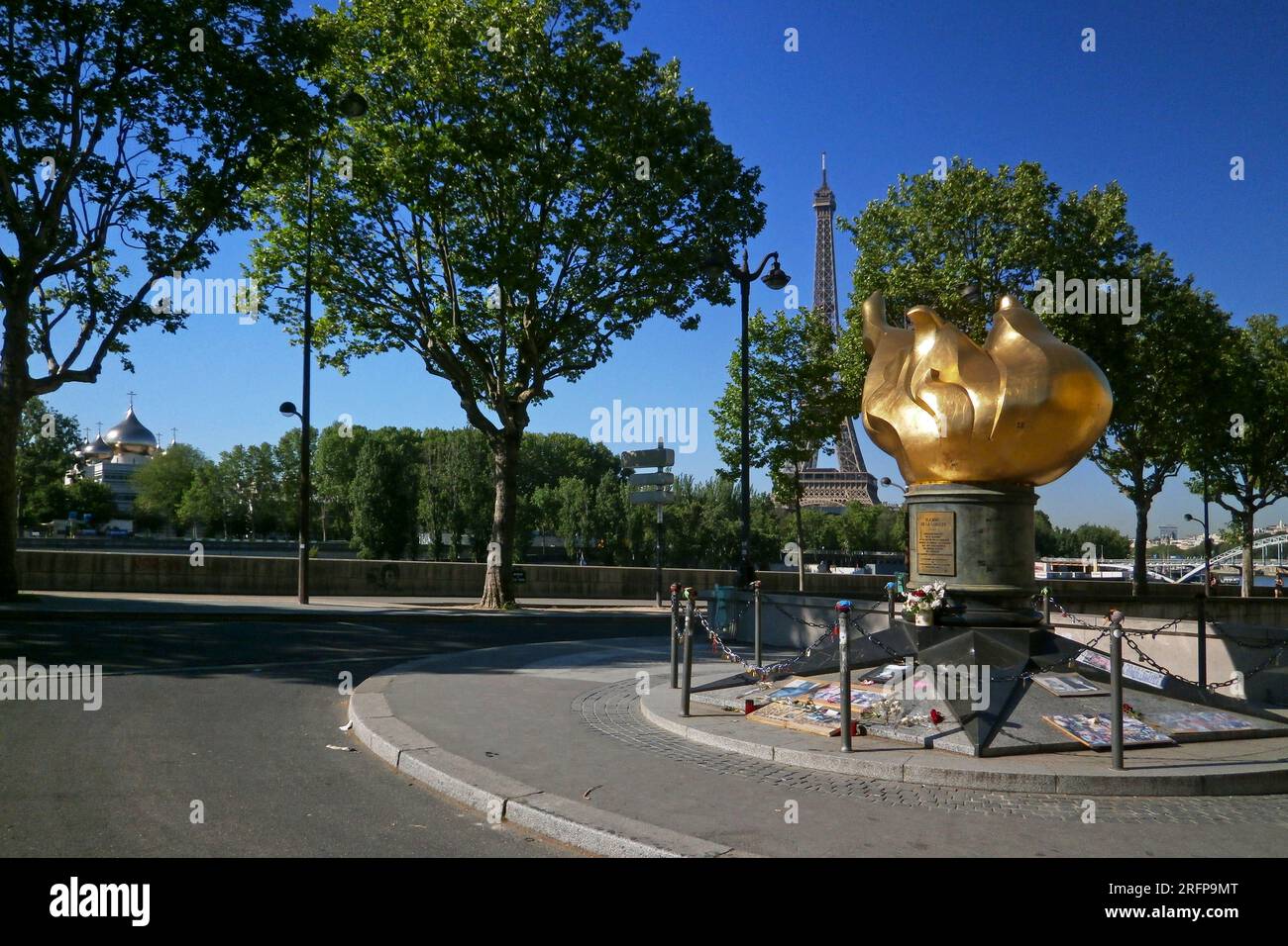 Paris, France - May 07 2018: Flamme de la Liberté near Pont de l'Alma with behind, the Eiffel Tower and the Cathédrale de la Sainte-Trinité. Stock Photo
