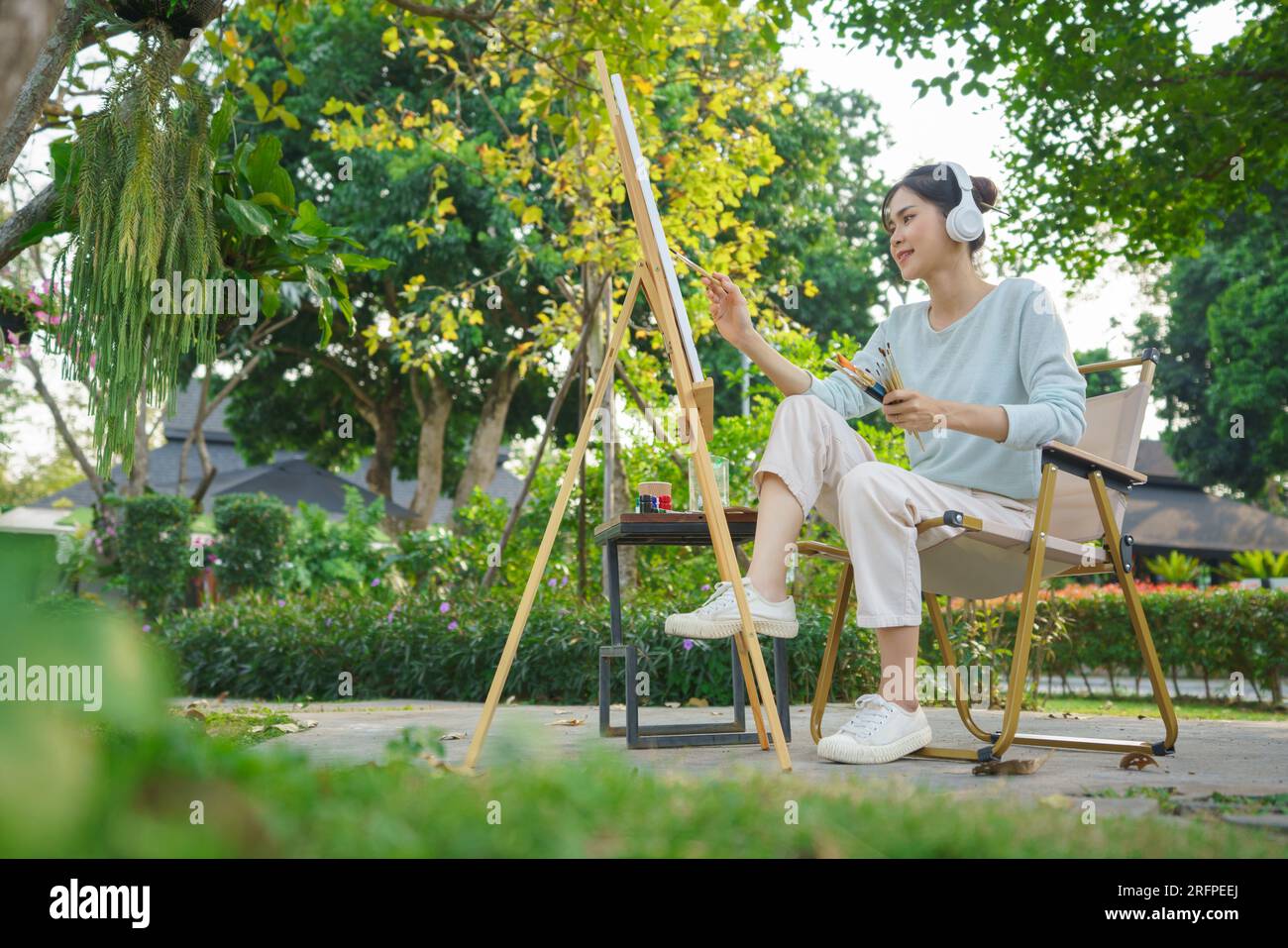 Outdoor activity concept, Female artist wears headphone to listening ...