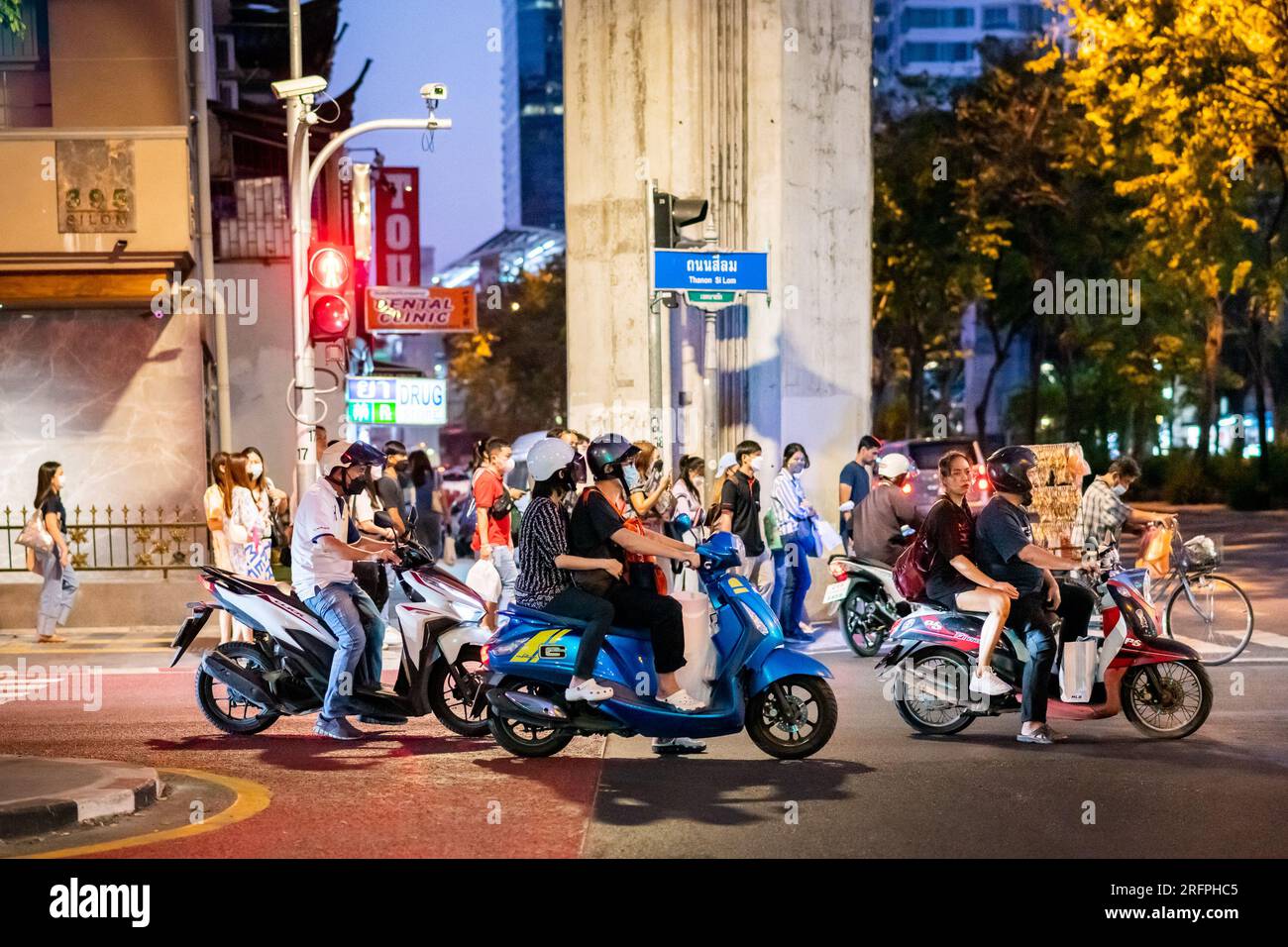 Motorbikes and mopeds wait at a traffic junction in the busy downtown