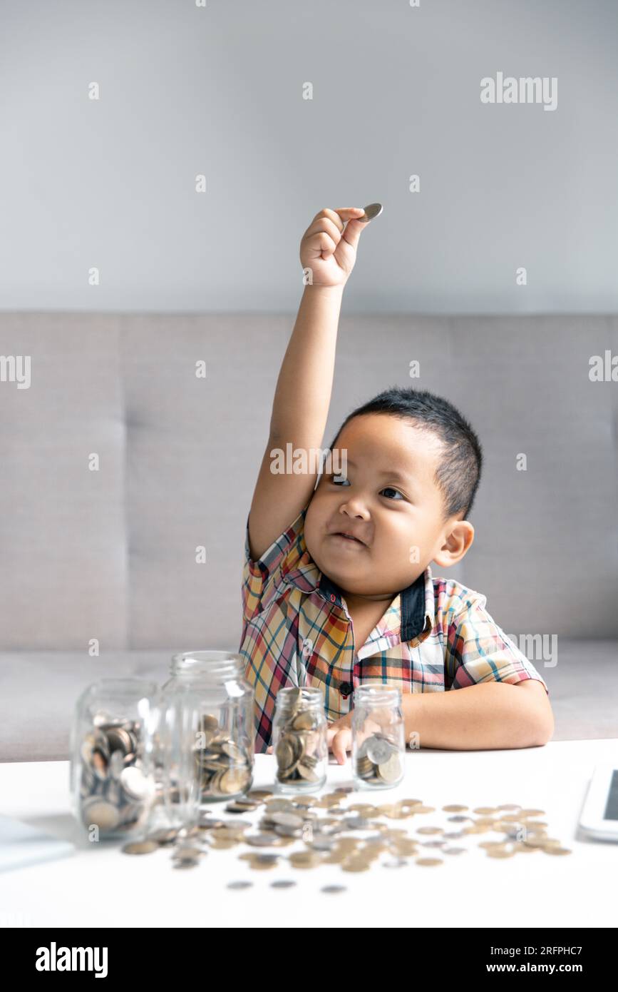 Preschooler child learning to calculate personal budget, manage finance, playing investment, accounting. Focused school kid saving money for purchase, Stock Photo