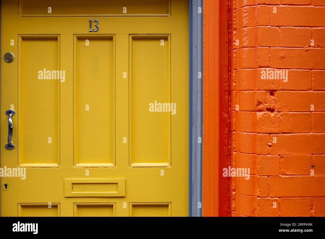 Closeup of yellow front door with orange brick wall Stock Photo Alamy