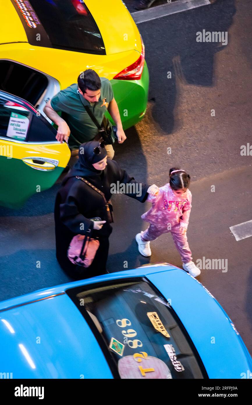 A Muslim family exit a taxi in the busy Bangkok city traffic on Sukhumvit Rd. in the Siam area of Bangkok City, Thailand. Stock Photo