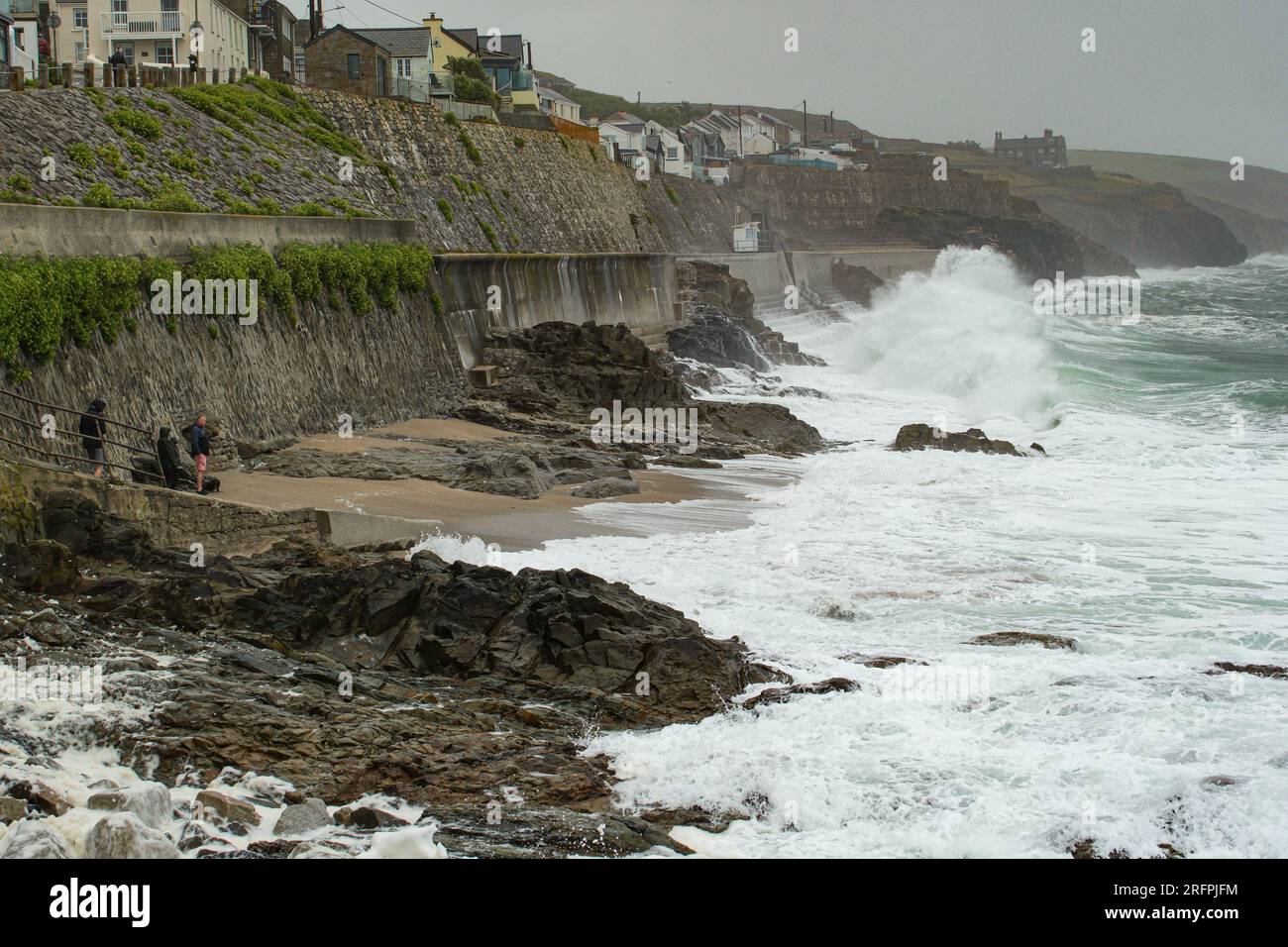 Porthleven, Cornwall, UK. 5th August 2023. UK Weather. A family dangerously close to the sea, taking pictures asas Storm Antoni starts to hit the UK at Porthleven this morning. Credit Simon Maycock / Alamy Live News. Stock Photo
