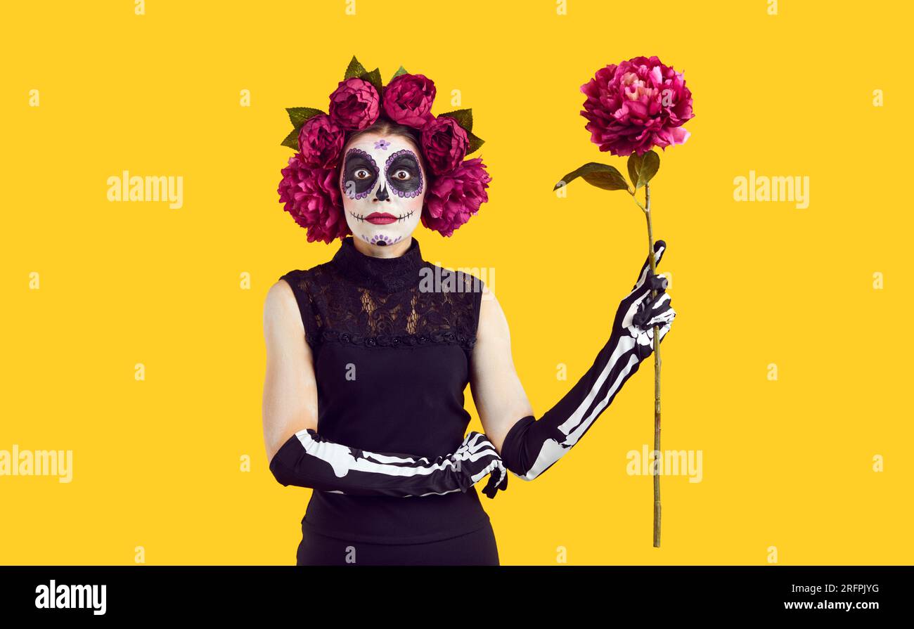 Young woman with sugar skull makeup in red peonies wreath Stock Photo
