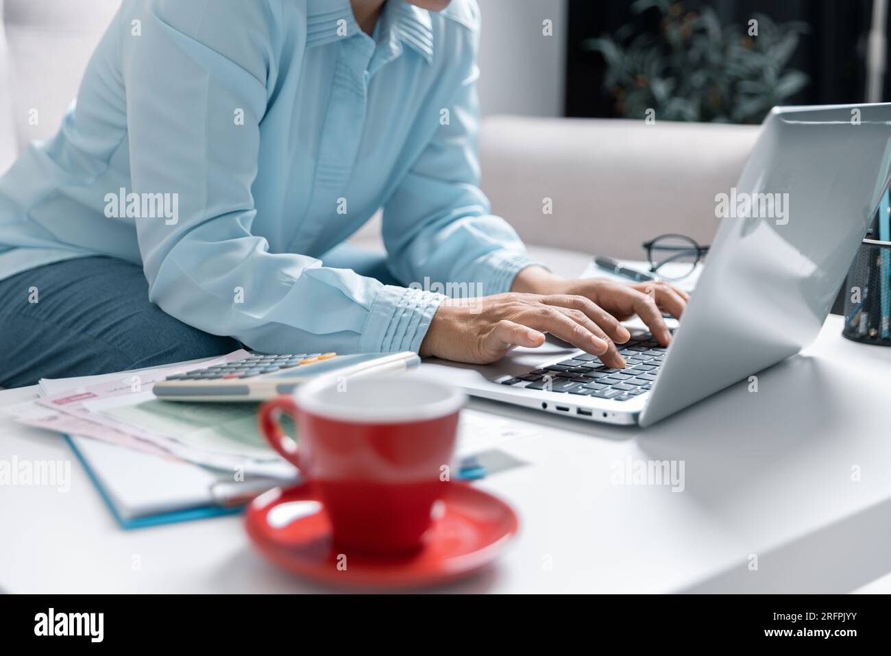 Concentrated Asian woman calculating expenditures, analyzing paper bank bills, managing monthly budget, planning investment, paying for service or uti Stock Photo