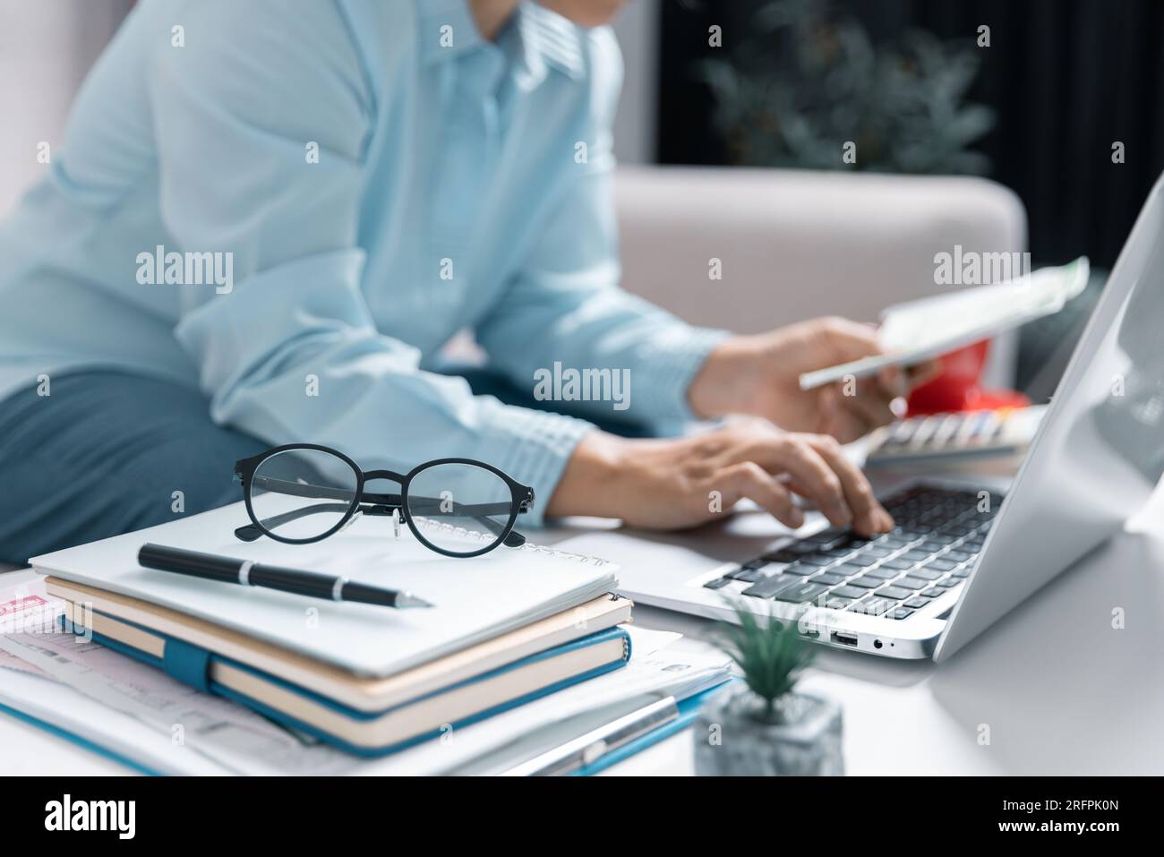 Concentrated Asian woman calculating expenditures, analyzing paper bank bills, managing monthly budget, planning investment, paying for service or uti Stock Photo