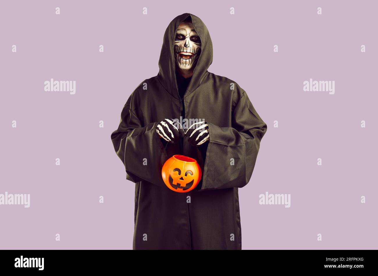 Scary man with skull makeup in hooded black cloak Stock Photo