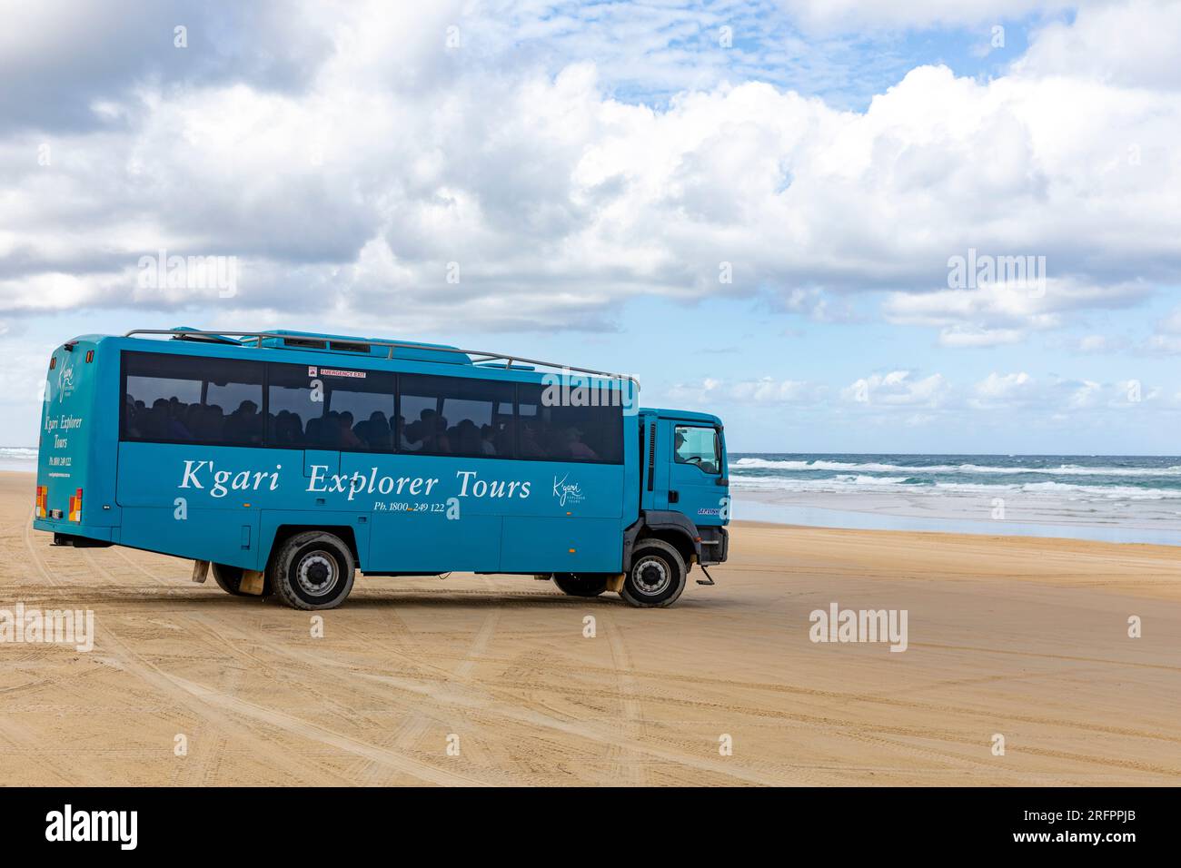 Fraser Island K'gari explorer tour bus driving along 75 mile beach which is a legal road, for tourists to visit sights, Queensland,Australia,2023 Stock Photo