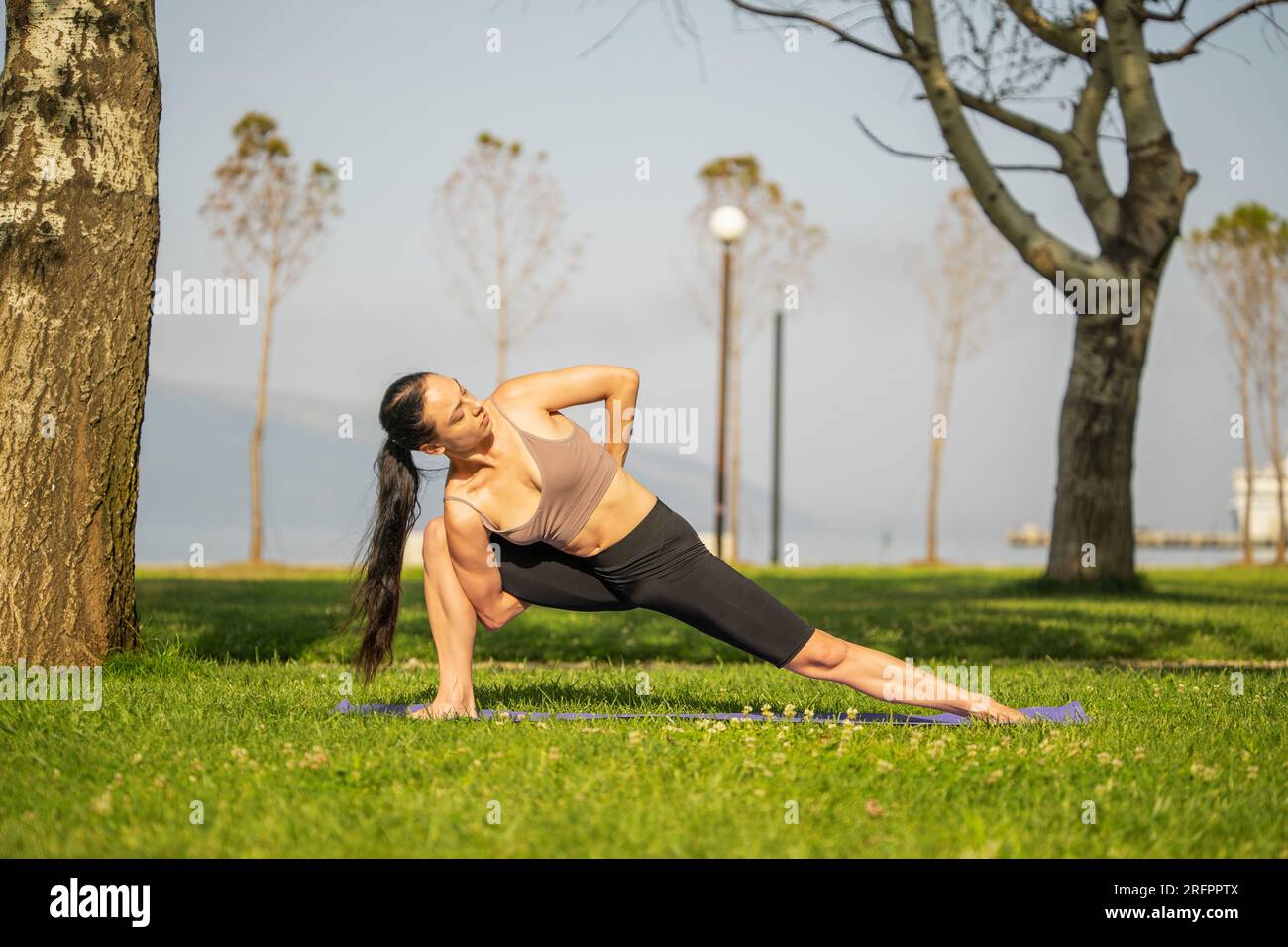 Athletic young woman doing yoga in the Park in the morning Stock