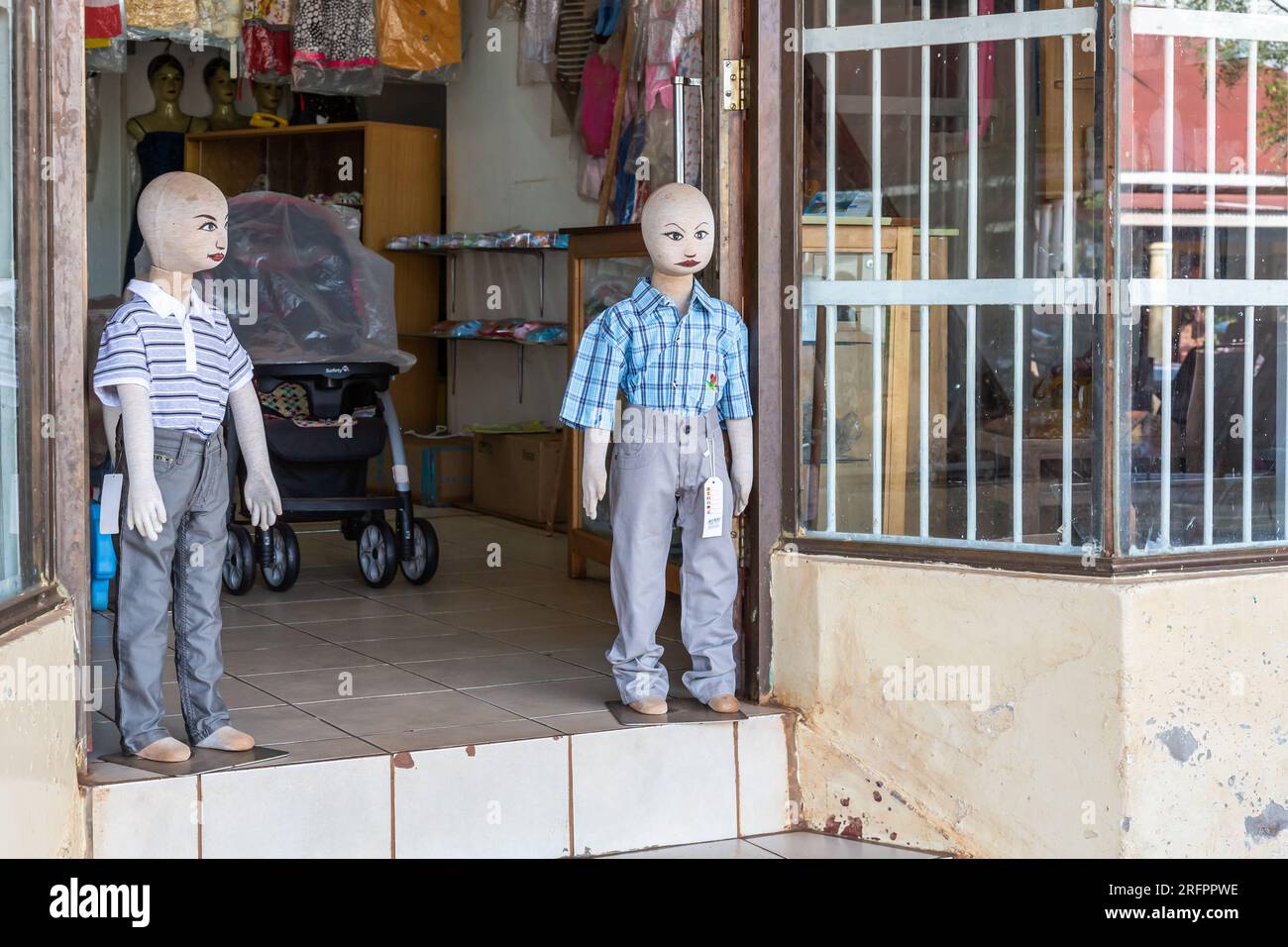 At the entrance to a store dedicated to children, two mannequins stand guard. Jinja, Uganda. Stock Photo