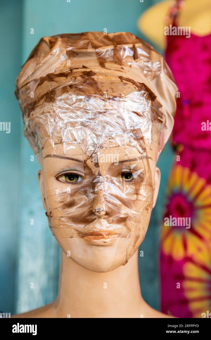 Face of a badly damaged mannequin, patched up with adhesive tape. Jinja