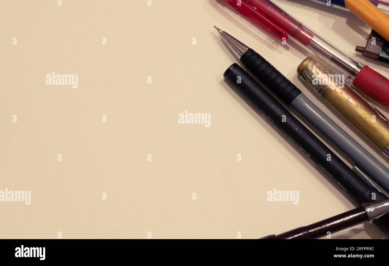 Different pens isolated on a beige - white background with copyspace ...