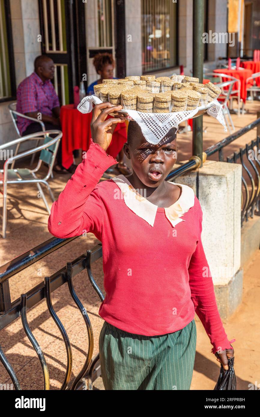 Young girl carrying a tray of cupcakes on his head. Jinja, Uganda Stock