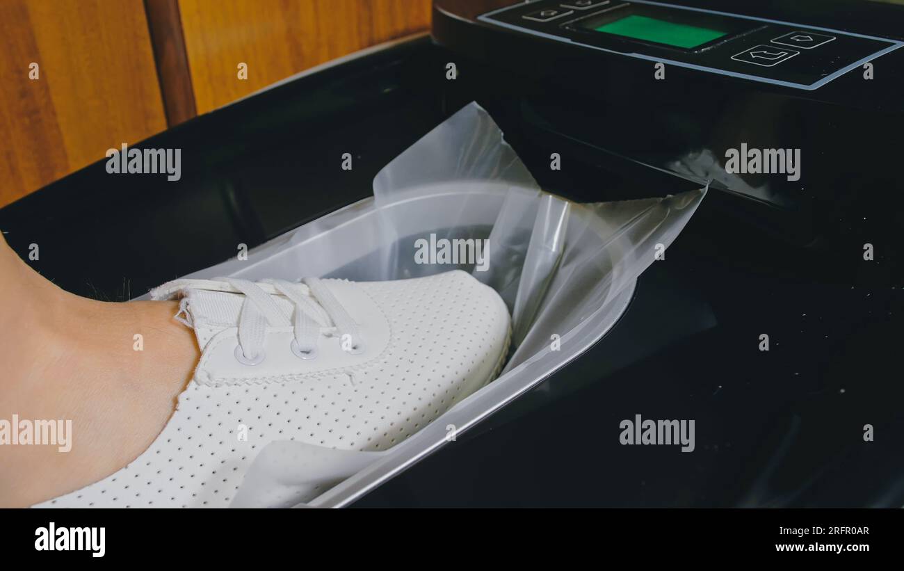 Automatic Thermal Shrinkable Shoe Cover Laminating Machine. Close up  dispenser in hospital hall. Machine automatically applies shoe covers to  the pati Stock Photo - Alamy