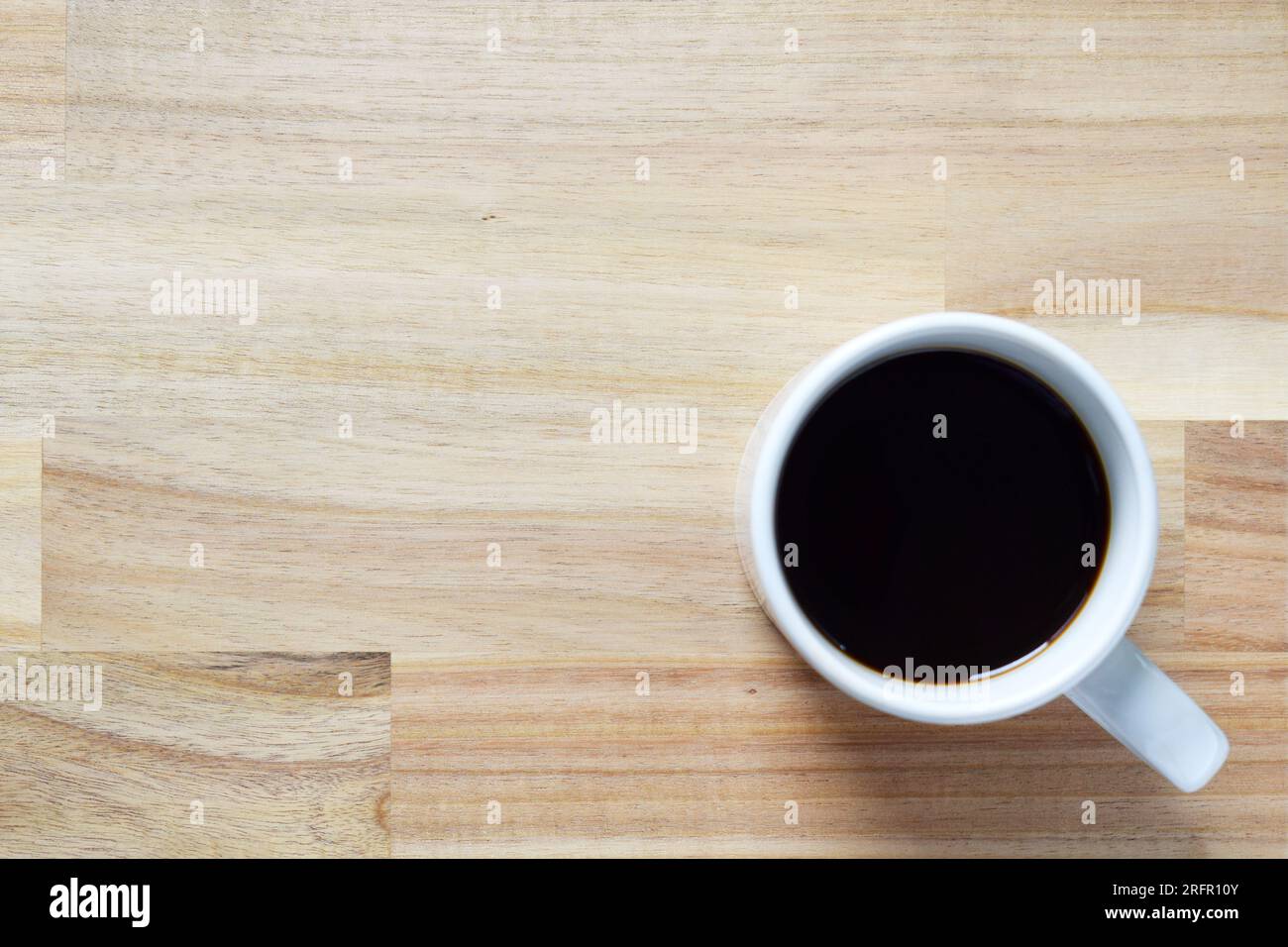 Wooden background with a blurred cup of coffee on it Stock Photo